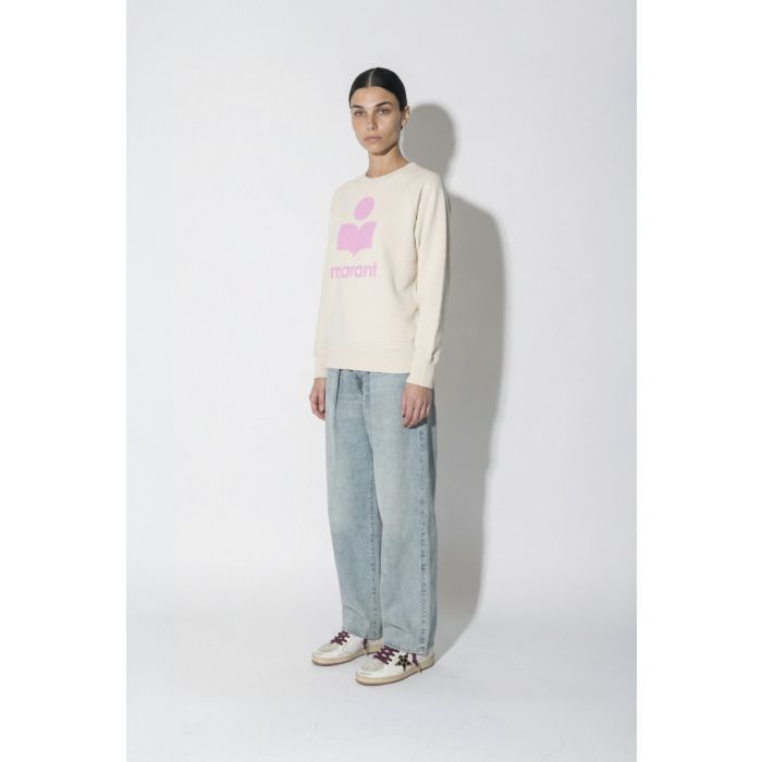 Sweatshirt Millyny Isabel Marant en coton écru logo rose devant, porté de profil avec un jean Candy Haikure et des sneakers Golden Goose.