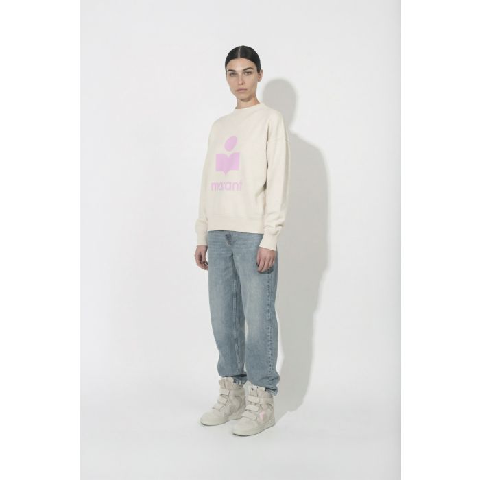 Sweatshirt Moby Isabel Marant étoile en coton écru et logo rose sur le devant, porté de profil avec un jean bleu et des baskets IM3 Isabel Marant.