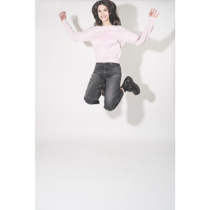 Sweat-shirt Mobyli Isabel Marant Étoile en coton rose clair, logo Marant, effet flou, porté avec le sourire.