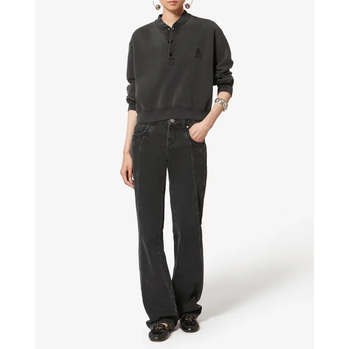 Sweatshirt court Simony Isabel Marant Etoile en coton noir délavé. Encolure boutonnées et logo brodé « Marant » ton sur ton sur la poitrine. Porté avec un jean noir.