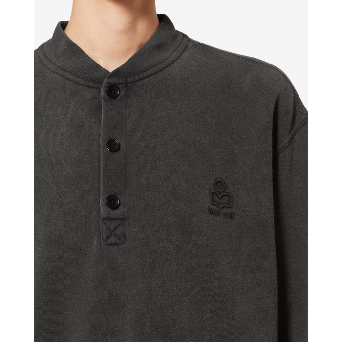 Sweatshirt court Simony Isabel Marant Etoile en coton noir délavé. Encolure boutonnées et logo brodé « Marant » ton sur ton sur la poitrine. Détail du col boutonné.