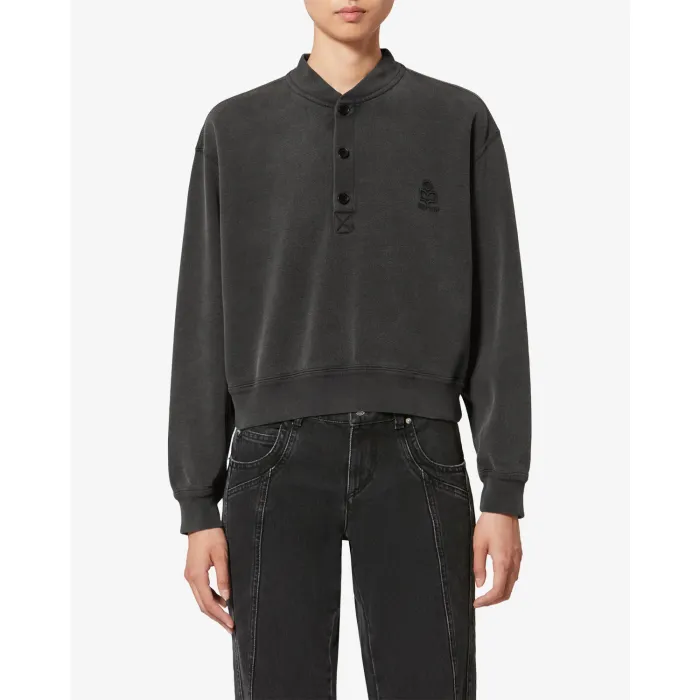 Sweatshirt court Simony Isabel Marant Etoile en coton noir délavé. Encolure boutonnées et logo brodé « Marant » ton sur ton sur la poitrine. Porté de face.