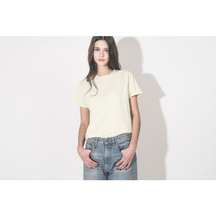 T-shirt Aby Isabel Marant Étoile en coton jaune pâle, logo brodé en écru au-dessus de la poitrine, porté de face avec un jean bleu.