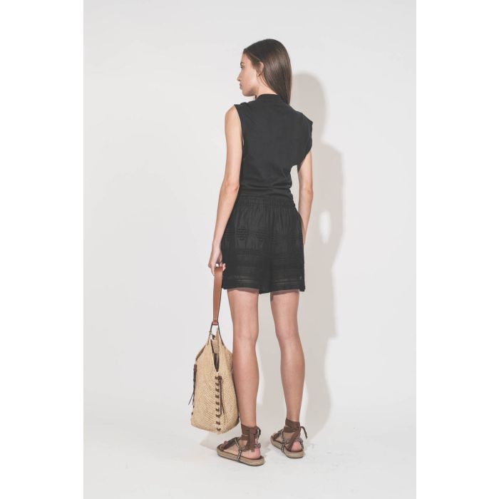 Tee-shirt sans manches noué d'un côté en jersey noir Nayda Marant Etoile. Porté de dos avec un short en voile de coton et dentelle noir Damina. Sandales Gypsa beige et panier en osier naturel Tampa Isabel Marant. Colliers De Jaegher. 