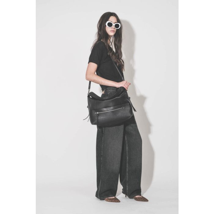 Jean large à pinces Rodayna Isabel Marant en lyocell Durty Blue, porté de profil avec un sac noir Jérôme Dreyfuss.