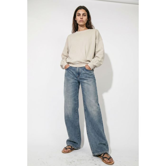 Jean fluide à pinces Rodayna Isabel Marant en denim bleu ciel. Coupe large porté de face avec un sweat-shirt beige.