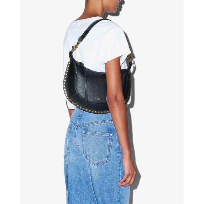 Sac Naoko Isabel Marant en cuir grainé noir, porté avec l'anse courte à l'épaule.