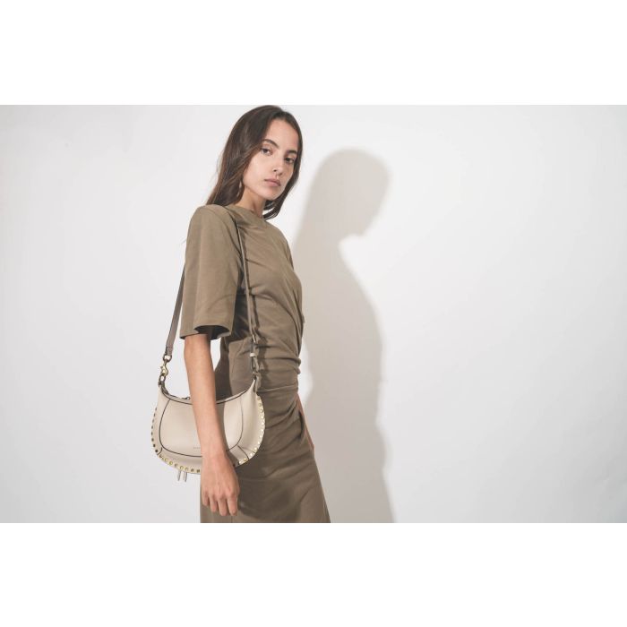 Mini sac en cuir écru clouté finition métal doré Oskan Moon Isabel Marant. Porté de face. 