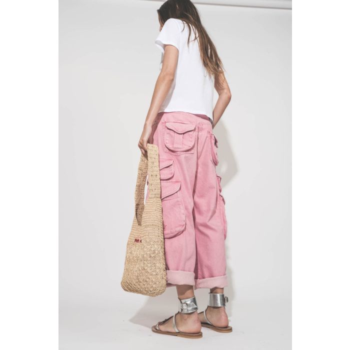Sac en raphia naturel logo Isabel Marant brodé rose et rouge Praia Isabel Marant. Porté main de dos avec un tee-shirt blanc Little blanc The Great, un jean multi-poches rose Cargo rose R13 et des sandales en cuir argent Caravelle K.Jacques St-Tropez. 