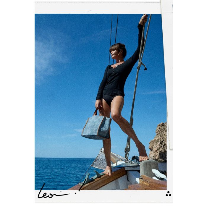 Sac cabas Léon M Jérôme Dreyfuss en cuir suédé jean bleu délavé, porté par Helena Christensen et photographié par Germain Chauveau à Ibiza.