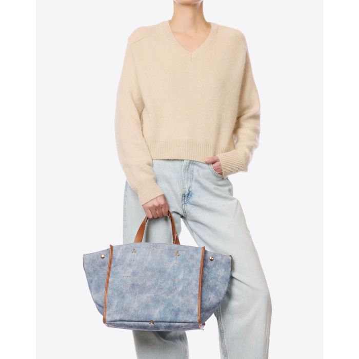 Sac cabas Léon M Jérôme Dreyfuss en cuir suédé jean délavé, porté de face à la main.