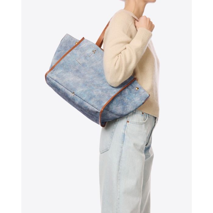 Sac cabas Léon M Jérôme Dreyfuss en cuir suédé jean délavé, porté à l'épaule.
