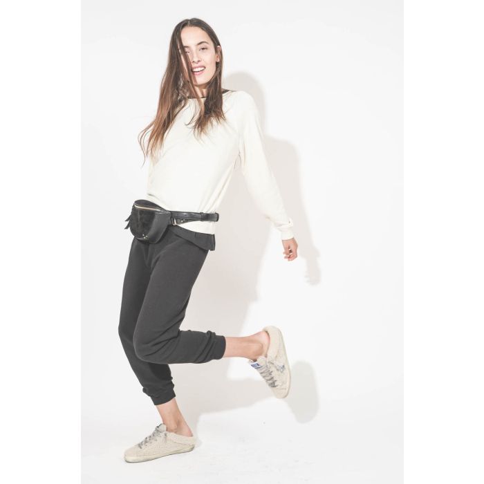 Sac banane en cuir chèvre grainé noir Lino Jérôme Dreyfuss. Porté à la taille avec un sweat-shirt écru Shrunken The Great et un pantalon de jogging court noir The Great. Sneakers Super Star sabot en Shearling écru Golden Goose.