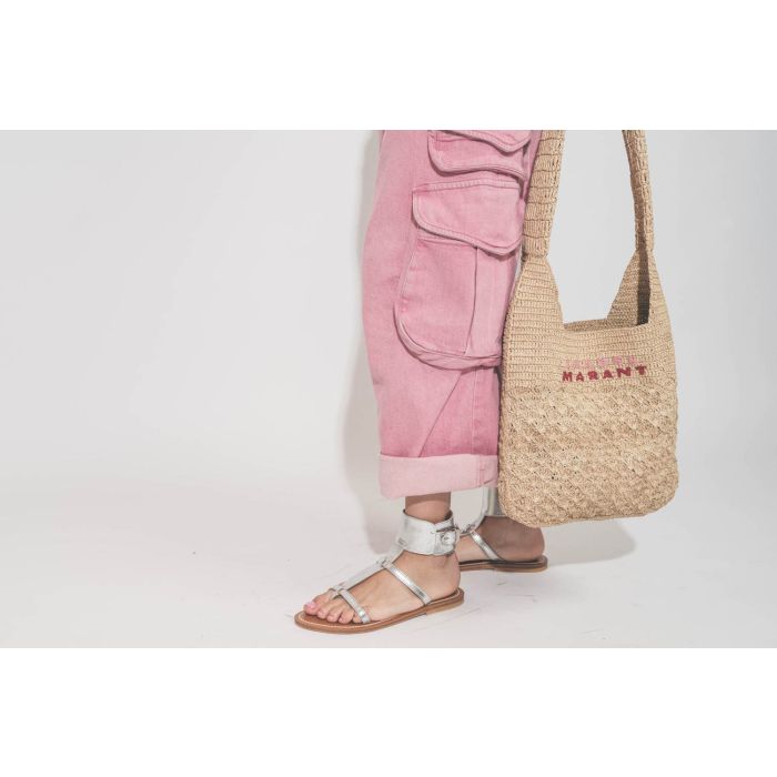 Sandales plates bracelet de cheville en cuir argent Caravelle K.Jacques St-Tropez. Porté avec un jean rose Cargo multi-poches R13 et un panier en raphia naturel logo rose et rouge Isabel Marant. 