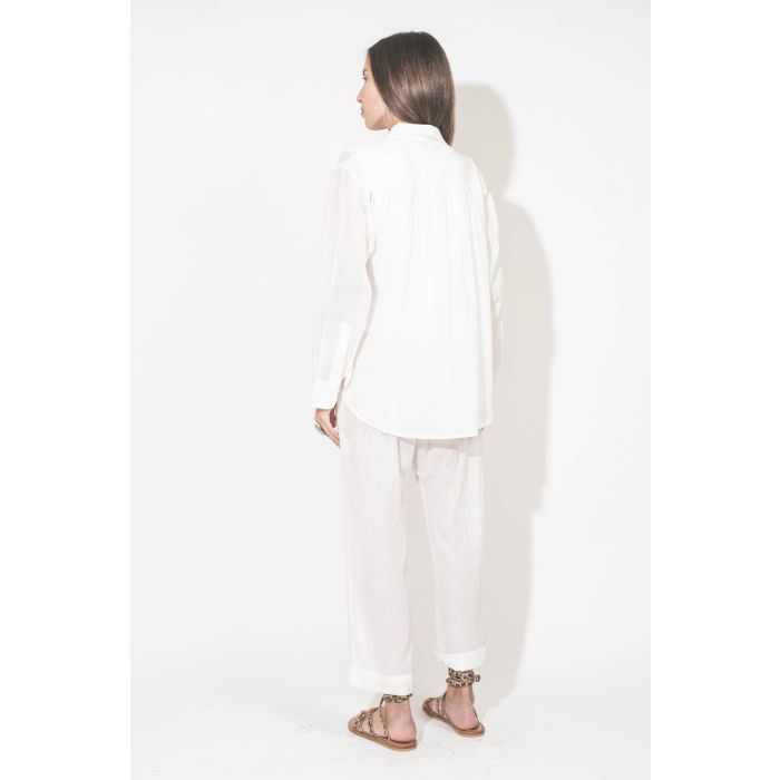 Sandales plates avec brides Zenobie K.Jacques St-Tropez en cuir "pony" léopard. Porté de dos avec un chemise en voile de coton blanc et un pantalon assorti en voile de coton blanc The Great. 