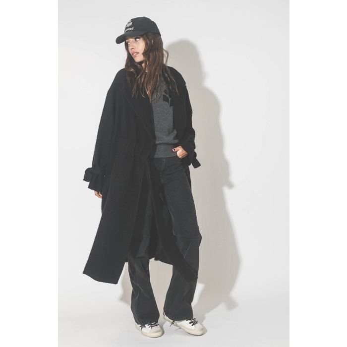 Manteau souple en laine noir Maison Flaneur. Porté avec un jean gris.
