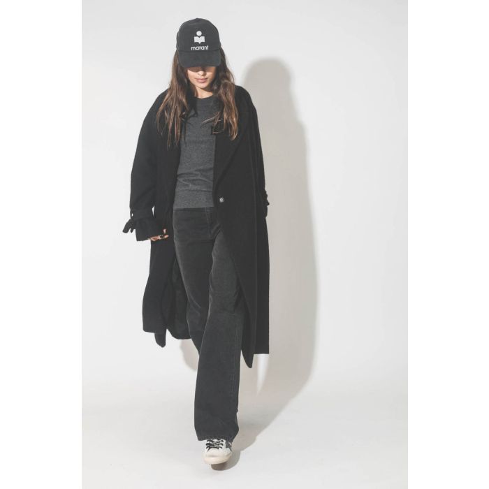Manteau souple en laine noir Maison Flaneur. Porté avec une casquette.