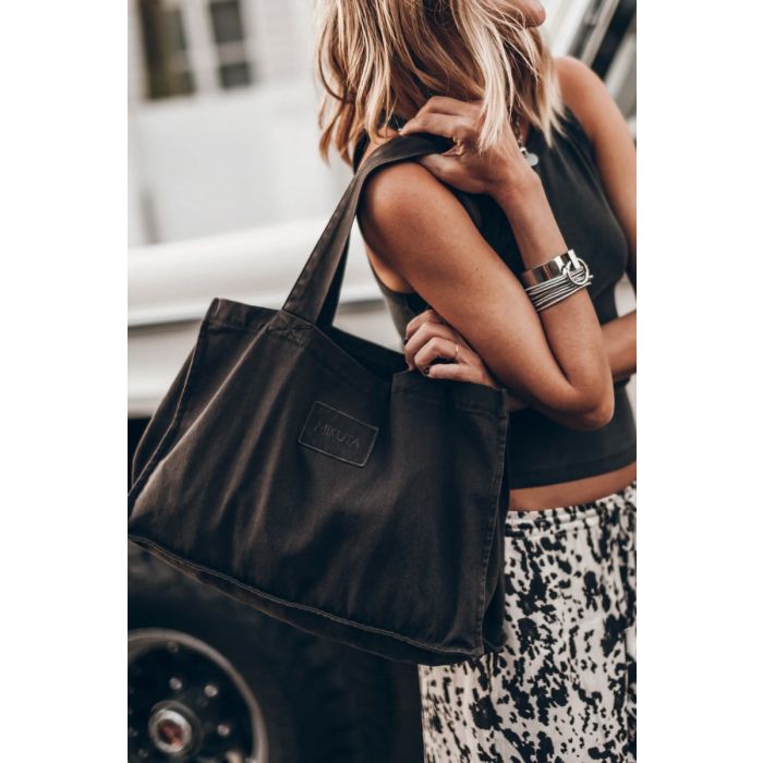 Sac petit cabas Mikuta en toile noir, porté à l'épaule.