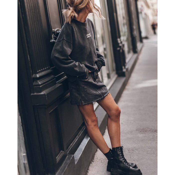 Mini-jupe en jeans gris métallisé vieilli Mikuta. Porté avec un sweat-shirt gris.