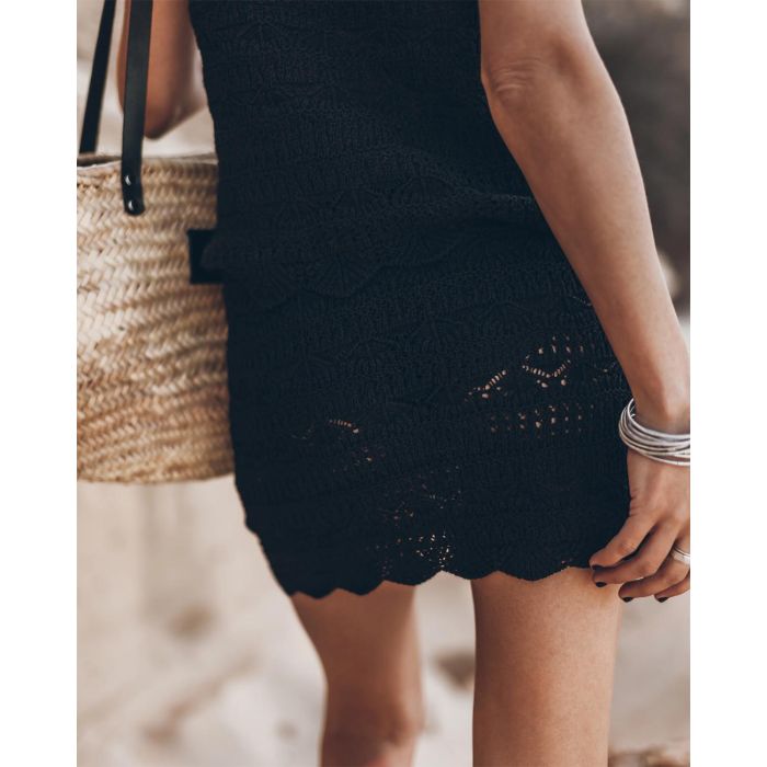 Mini-jupe en crochet noir en lin et coton Mikuta. Porté de dos avec un débardeur assorti et un panier en osier.