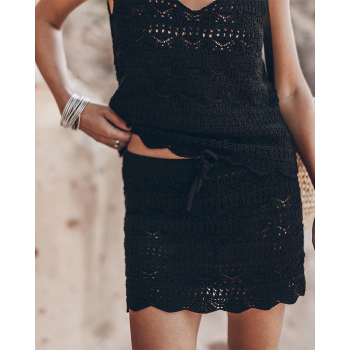 Mini-jupe en crochet noir en lin et coton Mikuta. Porté de face avec un débardeur en crochet noir assorti.