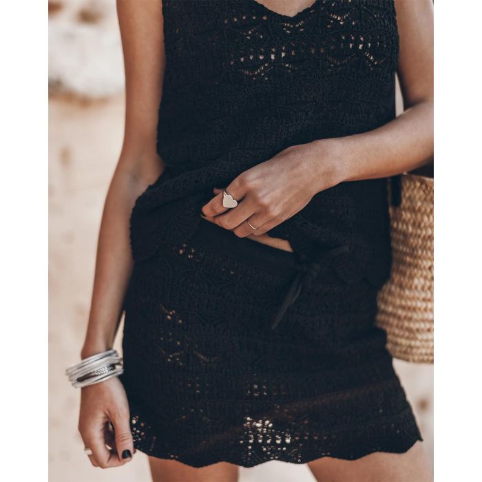 Mini-jupe en crochet noir en lin et coton Mikuta. Porté de face avec un débardeur en crochet noir assorti. Bague coeur en argent Mikuta.