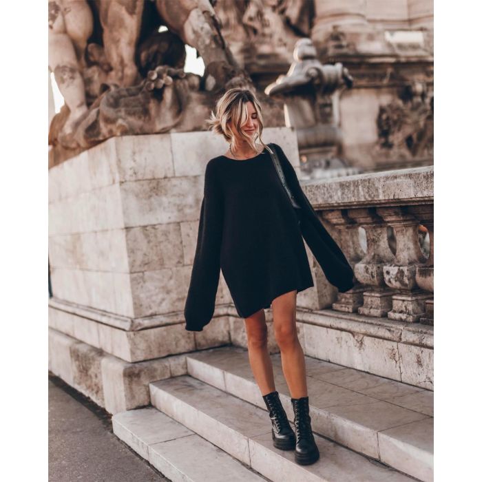 Pull long oversize Mikuta en mohair noir, porté avec un sac noir et des boots noires.