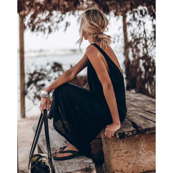 Robe longue dos nu Mikuta en jersey noir, portée de profil.