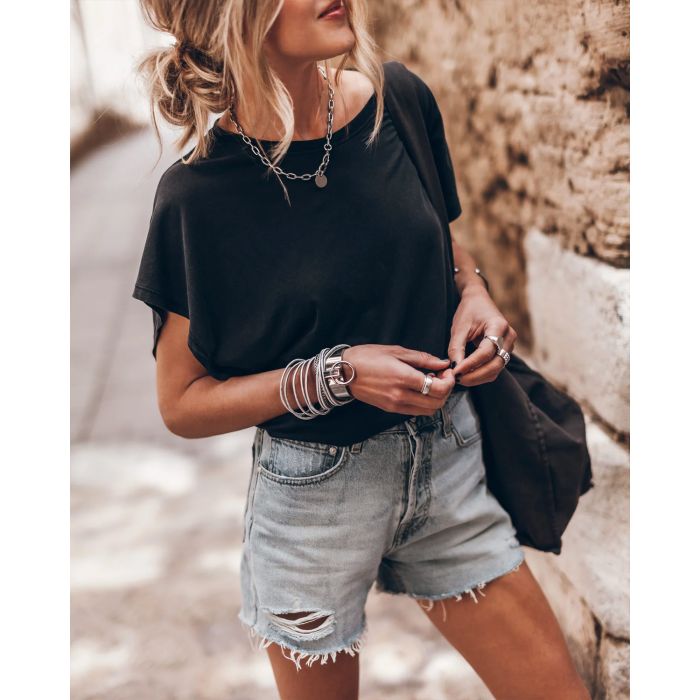 Tee-shirt manche Chauve-souris noir Mikuta. Porté avec un short en jean bleu.
