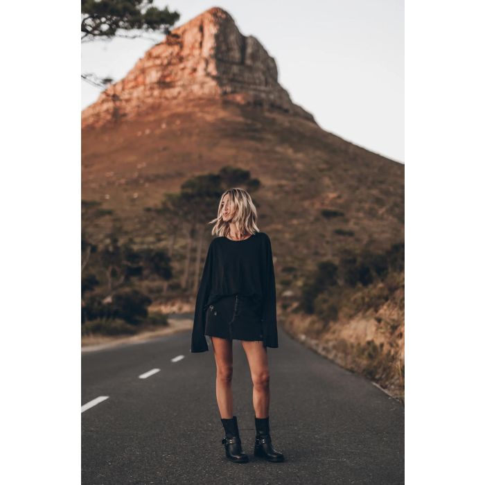 Tee-shirt Oversized Mikuta en lin noir. Vue face porté avec une jupe en denim noir. 