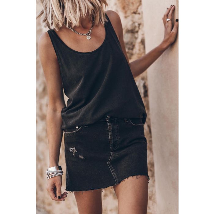 Débardeur emmanchure américaine torsade dans le dos en jersey de coton noir Mikuta. Porté de face avec un collier en argent Mikuta et une jupe en jean Mikuta.