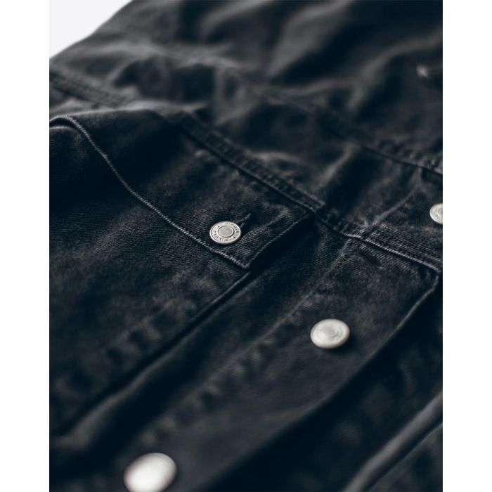 Veste en denim noir Mikuta. Détail des boutons en métal argenté gravé « MIKUTA ».