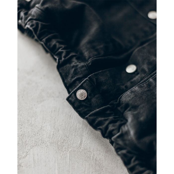Veste en denim noir Mikuta. Détail du bas élastiqué.