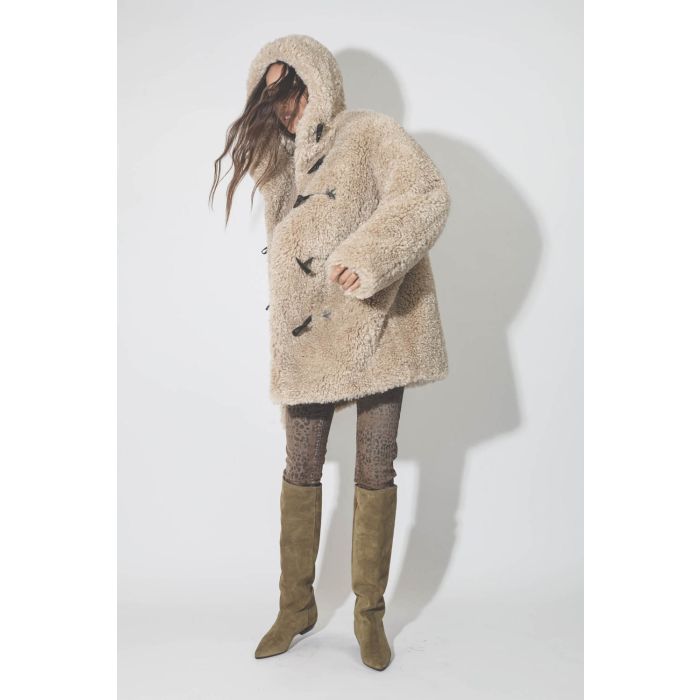 Manteau 3/4 à capuche en fausse fourrure beige Florene Marant Etoile. Porté avec des bottes en cuir suédé beige.