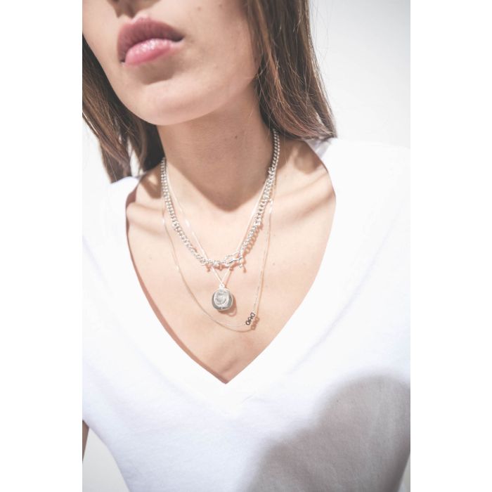 Collier en argent chaine avec une médaille en argent gravée "GB.03" et pavée de diamants et une médaille en cristal de roche gravée "AMOUR" Pascale Monvoisin. Porté en accumulation avec un collier chaine en argent Berline Maria Black et un collier chaine 