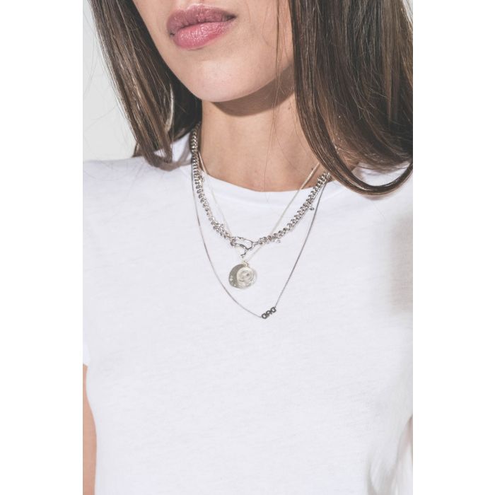 Collier en argent chaine avec une médaille en argent gravée "GB.03" et pavée de diamants et une médaille en cristal de roche gravée "AMOUR" Pascale Monvoisin. Porté en accumulation avec un collier chaine Berline Maria Black et un collier chaine "DAD" Mari