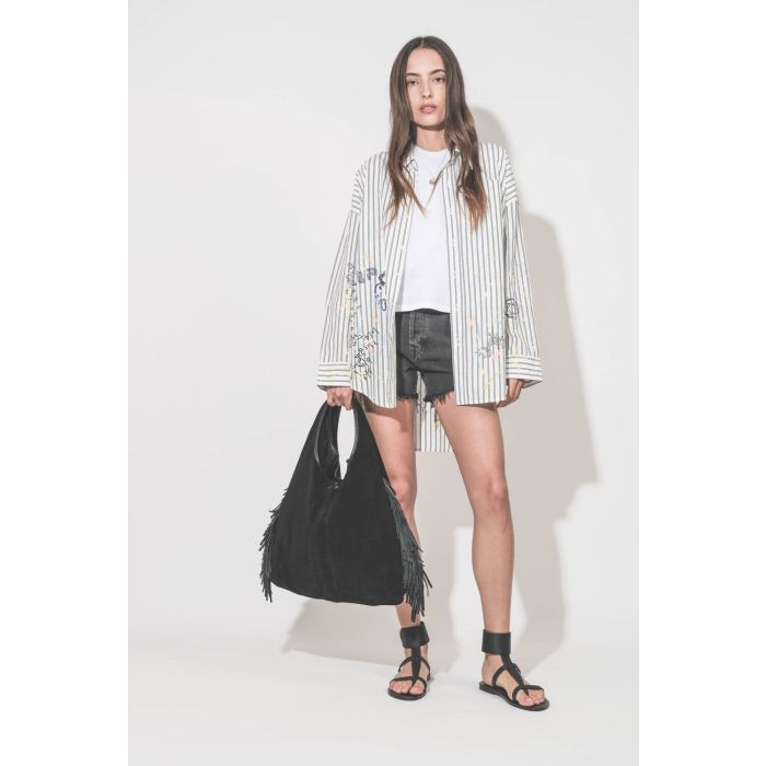 Chemise oversized en popeline blanche à rayures noires et graffiti Drop Neck R13. Portée de face avec un short en jean noir Mikuta, des sandales Caravelle K.Jacques St Tropez et un sac à franges Paco Jérôme Dreyfuss.