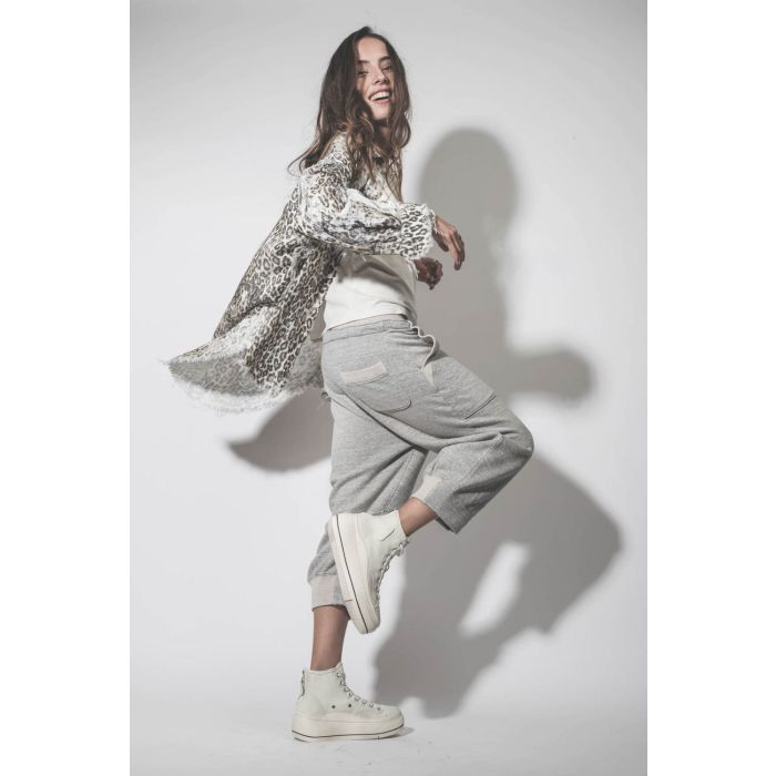 Chemise oversize en coton imprimé léopard délavé bord franc Shredded léopard R13. Porté avec un pantalon de jogging gris.