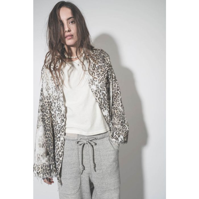 Chemise oversize en coton imprimé léopard délavé bord franc Shredded léopard R13. Porté ouverte sur un tee-shirt écru.