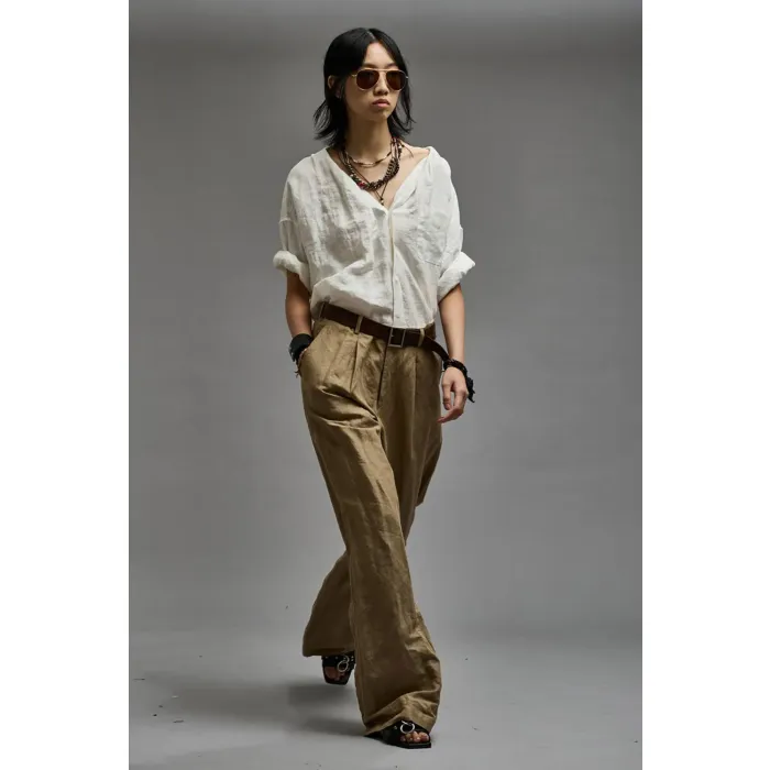 Chemise  froissée manches longues sans col en lin et viscose blanche Twisted Neck Shirt R13. Porté avec un pantalon beige.  