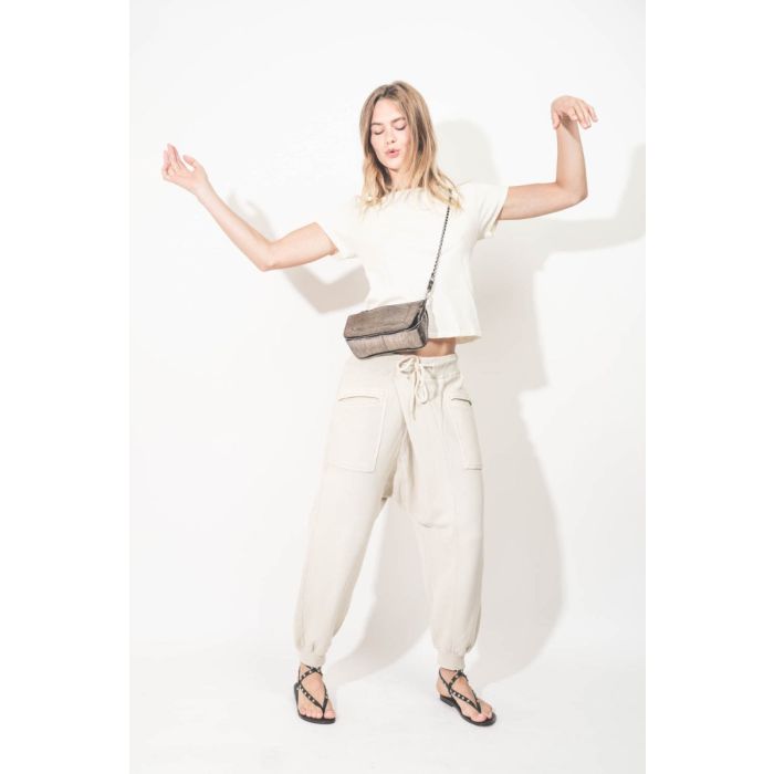 Pantalon de jogging Crossover Sweatpant R13 en coton mélangé naturel. Porté avec un tee-shirt écru.