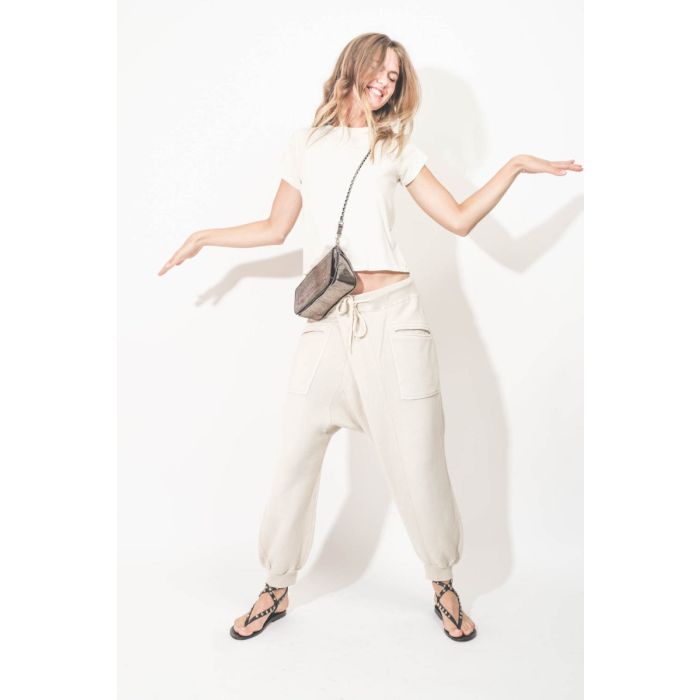 Pantalon de jogging Crossover Sweatpant R13 en coton mélangé naturel. Porté avec un sac en bandoulière.