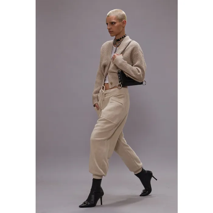 Pantalon de jogging Crossover Sweatpant R13 en coton mélangé naturel. Porté de profil avec des boots à talons.
