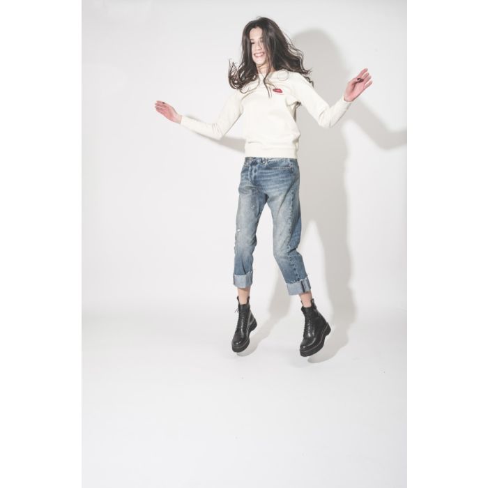 Jean Crossover R13 en denim bleu délavé Jasper, porté avec un sweatshirt Bisous.