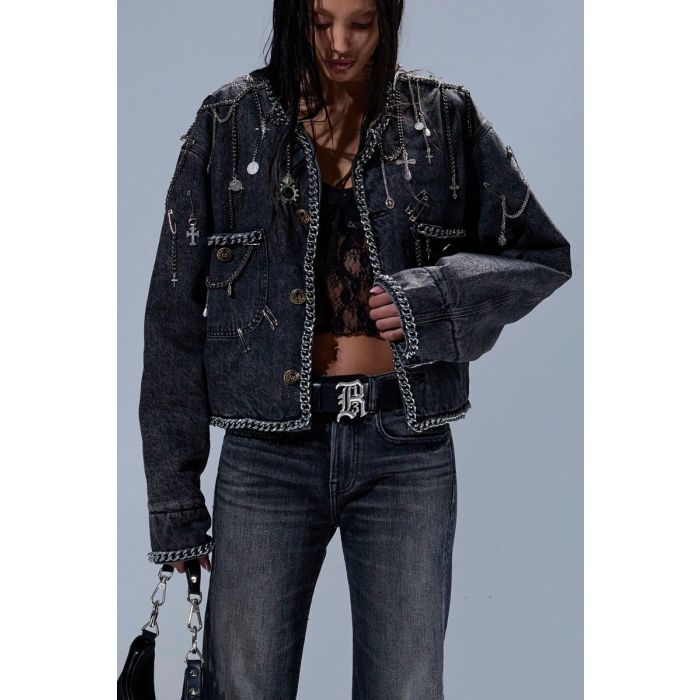 Veste courte Chain Embellished Cropped Chore Jacket R13 en denim gris foncé, customisée avec des chaînes, des épingles à nourrice et des médailles en métal argenté. Portée de face.