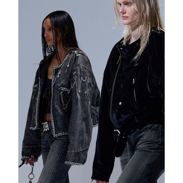 Veste courte Chain Embellished Cropped Chore Jacket R13 en denim gris foncé, customisée avec des chaînes, des épingles à nourrice et des médailles en métal argenté. Portée de profil.