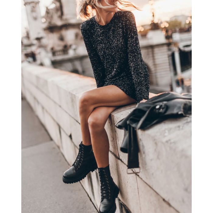 Robe courte manches longues à paillettes dos nu noire Mikuta. Porté avec un Perfecto en cuir noir.
