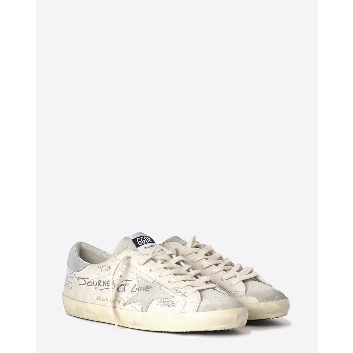Sneakers Superstar Golden Goose en cuir blanc avec dessins. Vue face. 