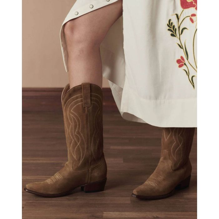 Bottes de cowboy Stetson & The Great en daim camel, portées de profil avec une jupe longue The Great. Edition limitée.