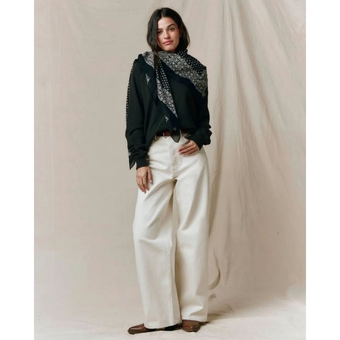 Grand foulard Bandana The Great en coton noir délavé, noué sur le côté autour du cou.